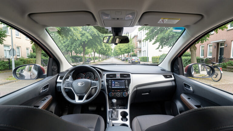 Vue depuis le siège conducteur d’une voiture moderne offrant une bonne visibilité grâce à ses larges vitres, ses montants fins et ses rétroviseurs bien réglés.